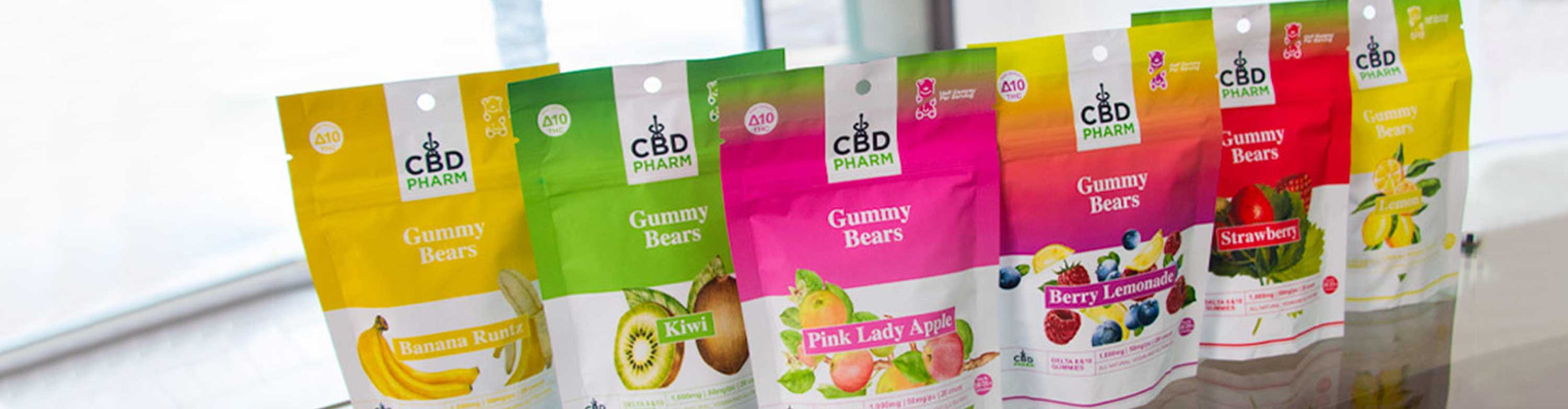 CBD Pharm Gummies standing on wooden glass table inside office lobby